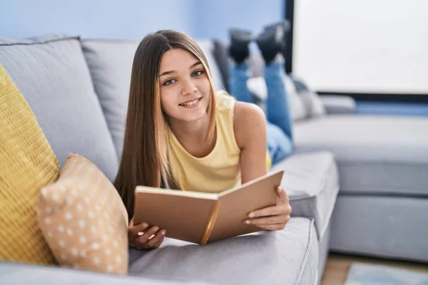 Adorable Girl Reading Book Lying Sofa Home — Fotografia de Stock