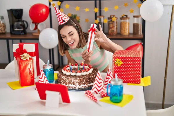 Young Beautiful Hispanic Woman Celebrating Online Birthday Holding Gift Home — Foto de Stock