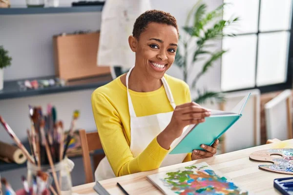 African American Woman Artist Smiling Confident Reading Book Art Studio — Stock Photo, Image