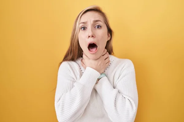 Young Caucasian Woman Wearing White Sweater Yellow Background Shouting Suffocate — Stock Photo, Image