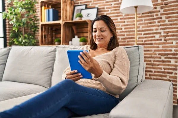 Middle Age Hispanic Woman Using Touchpad Sitting Sofa Home — Fotografia de Stock