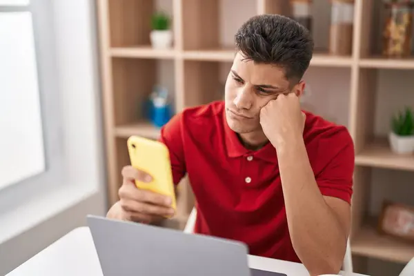 Young Hispanic Man Using Laptop Smartphone Relaxed Expression Home — Foto Stock