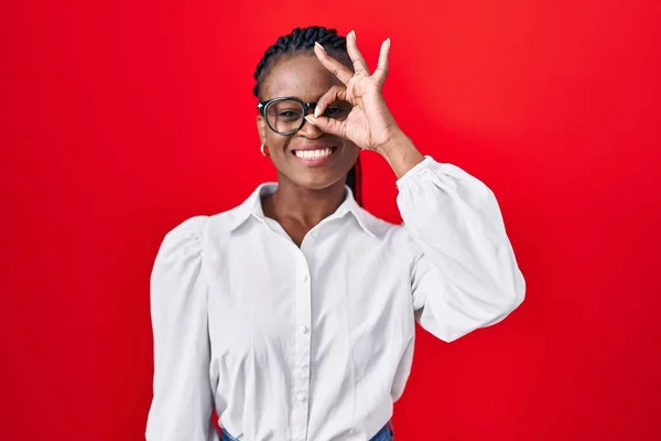 Kırmızı Arka Planda Dikilmiş Örgü Ören Afrikalı Kadın Hareketleriyle Gülümsüyor — Stok fotoğraf