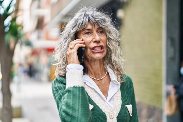 Orta Yaşlı Bir Kadın Gülümsüyor Sokakta Akıllı Telefondan Konuşuyor — Stok fotoğraf