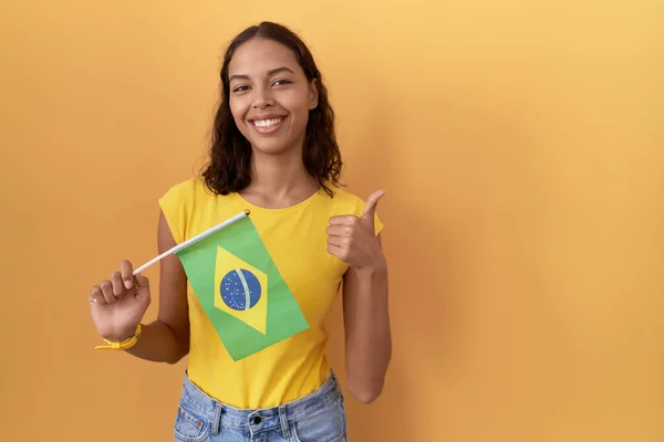 Mladá Hispánka Držící Brazilskou Vlajku Dělá Šťastné Gesto Rukou Nahoru — Stock fotografie