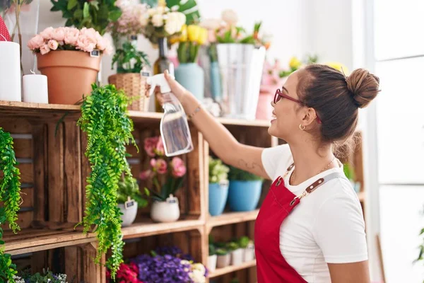 stock image Young beautiful hispanic woman florist using diffuser working at florist