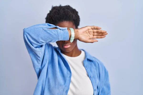 Африканская Американка Стоящая Синем Фоне Закрывая Глаза Рукой Выглядит Серьезной — стоковое фото