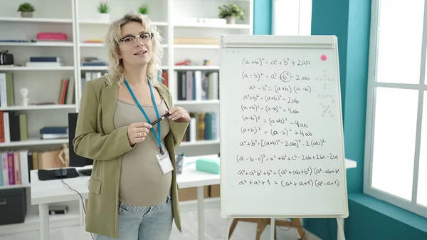 教室で磁気ボード上の数学を教える若い妊婦 — ストック写真