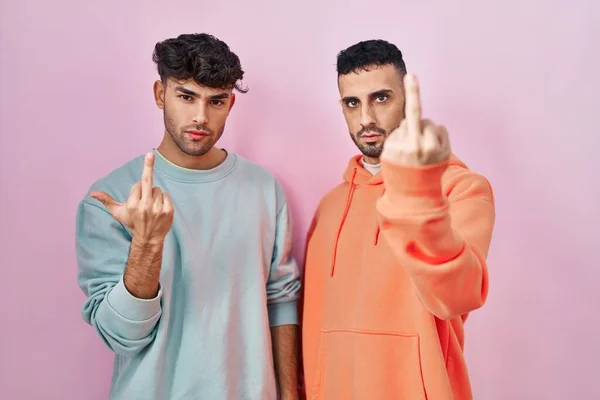 Young Hispanic Gay Couple Standing Pink Background Showing Middle Finger —  Fotos de Stock