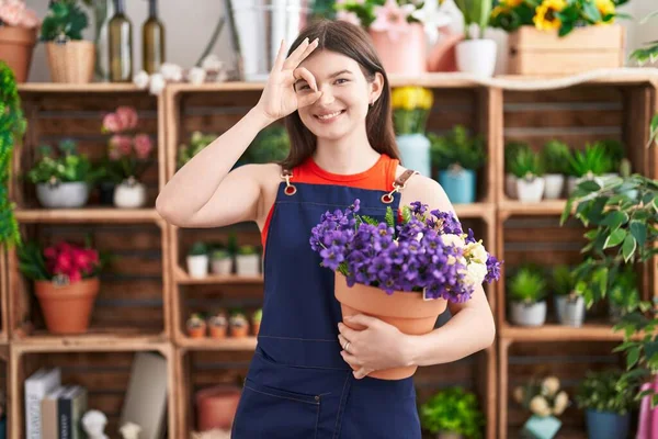 Joven Mujer Caucásica Trabajando Floristería Sosteniendo Maceta Con Flores Sonriendo —  Fotos de Stock
