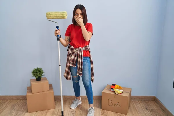 Young Hispanic Woman Painting Home Walls Paint Roller Shocked Covering — Stock Photo, Image