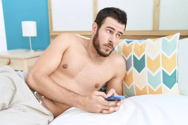 Νεαρός Ισπανός Που Χρησιμοποιεί Smartphone Ξαπλωμένος Στο Κρεβάτι Στην Κρεβατοκάμαρα — Φωτογραφία Αρχείου