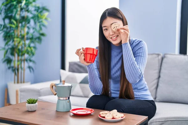 Chinês Mulher Tomando Café Manhã Segurando Biscoito Sobre Olhos Casa — Fotografia de Stock