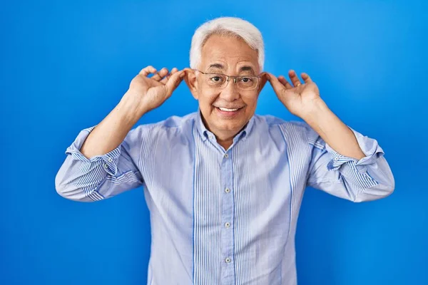 Hispanic Senior Man Wearing Glasses Smiling Pulling Ears Fingers Funny — Stock Photo, Image