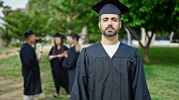 学生グループは大学キャンパスでリラックスした表情で立って卒業しました — ストック写真