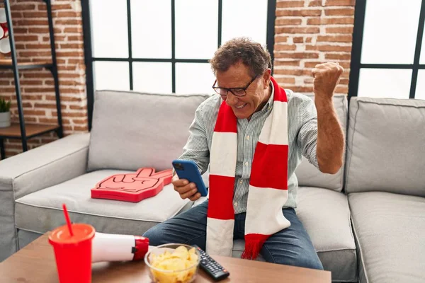 Senior Oglądanie Piłki Nożnej Patrząc Smartfona Krzycząc Dumny Świętując Zwycięstwo — Zdjęcie stockowe