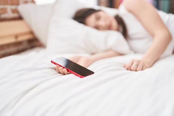 Młoda Kaukaska Kobieta Trzyma Smartfon Śpi Łóżku Sypialni — Zdjęcie stockowe