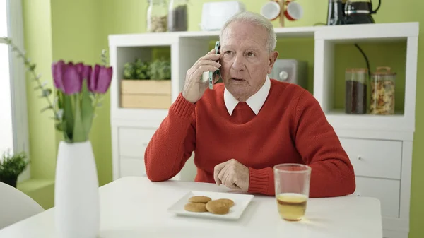 Senior Mangiare Biscotti Bere Succo Frutta Parlando Telefono Casa — Foto Stock
