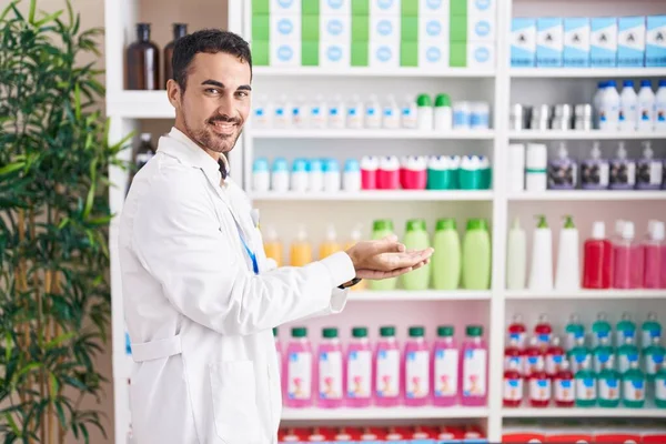 Handsome Hispanic Man Working Pharmacy Drugstore Pointing Aside Hands Open — Stock Photo, Image