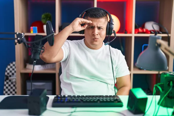若いヒスパニック系の男が心配してビデオゲームをプレイし 額に手で問題について強調 神経と危機への不安 — ストック写真
