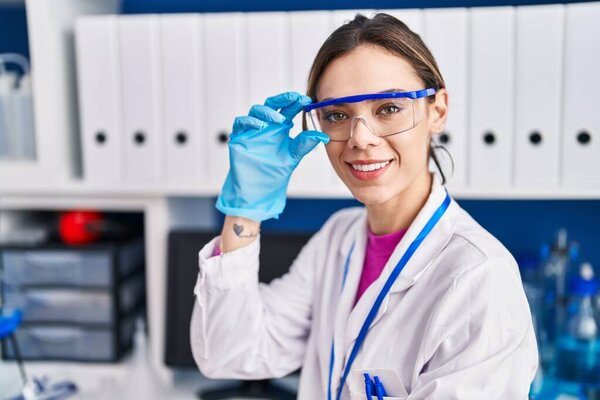 Young beautiful hispanic woman scientist smiling confident standing at laboratory
