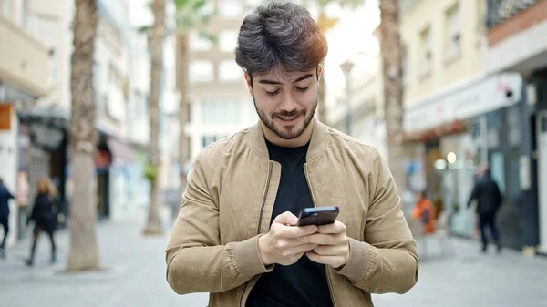 Joven Hombre Hispano Usando Smartphone Sonriendo Calle —  Fotos de Stock