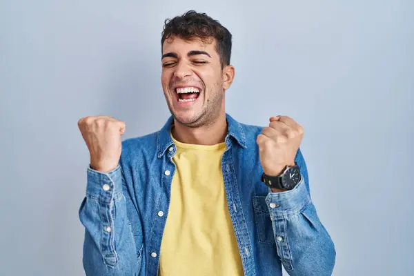 Young Hispanic Man Standing Blue Background Celebrating Surprised Amazed Success — Stockfoto