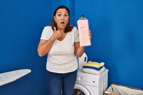 Middle Age Hispanic Woman Holding Detergent Bottle Scared Amazed Open — Stock Photo, Image