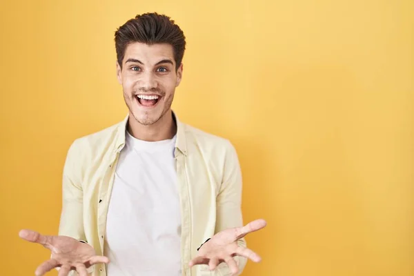 Young Hispanic Man Standing Yellow Background Smiling Cheerful Open Arms — Stock Fotó