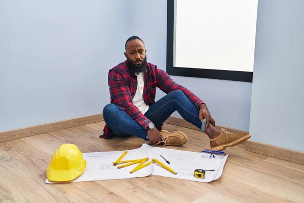 African American Man Sitting Floor New Home Looking Blueprints Depressed — Stock Photo, Image