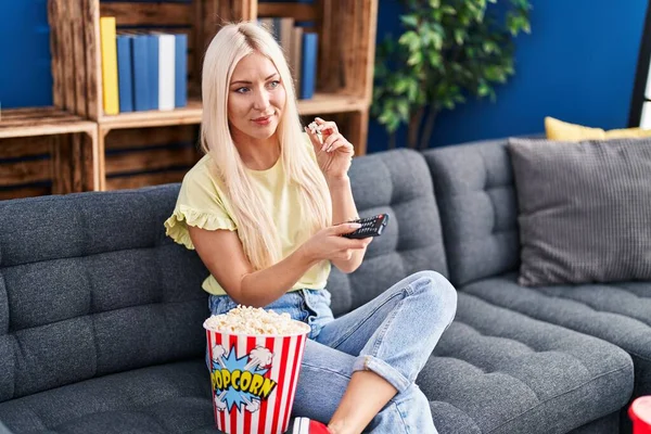 Young Blonde Woman Watching Movie Sitting Sofa Home — Stok fotoğraf