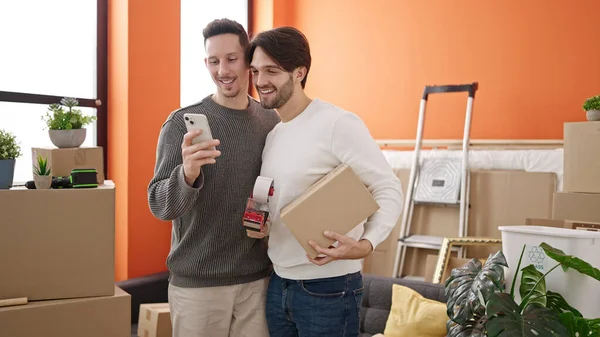 Двое Мужчин Используют Пакет Смартфонов Новом Доме — стоковое фото
