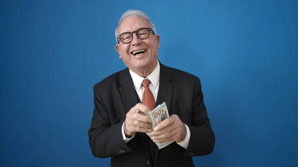 Senior Sonriendo Confiado Contando Dólares Sobre Aislado Fondo Azul —  Fotos de Stock