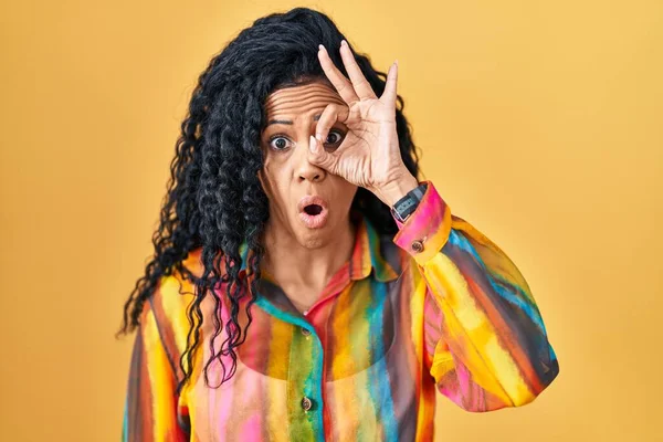 Middle Age Hispanic Woman Standing Yellow Background Doing Gesture Shocked — Stockfoto