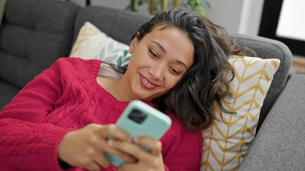 Young Beautiful Hispanic Woman Using Smartphone Lying Sofa Home — Stock Photo, Image