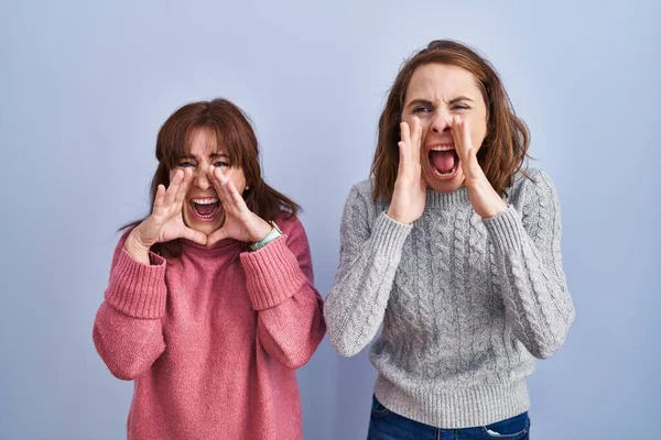 Mother Daughter Standing Blue Background Shouting Angry Out Loud Hands — Stock Photo, Image