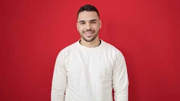 Jonge Latino Man Glimlachen Zelfverzekerd Staande Geïsoleerde Rode Achtergrond — Stockfoto