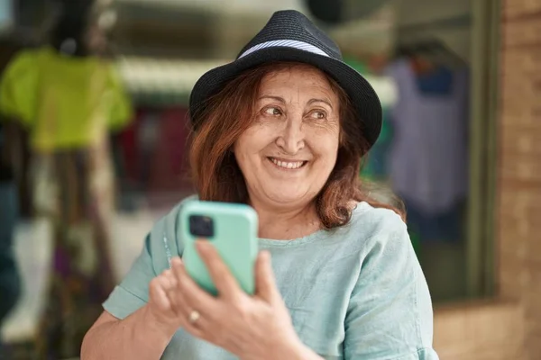 Старшая Женщина Улыбается Уверенно Используя Смартфон Улице — стоковое фото