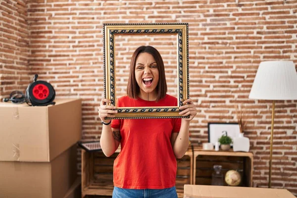 Young Hispanic Woman New Home Holding Empty Frame Angry Mad — Stock Photo, Image