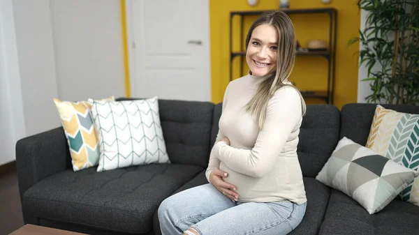 Young Pregnant Woman Smiling Confident Touching Belly Home — Stok fotoğraf