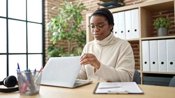 アフリカ系アメリカ人女性ビジネスワーカーがオフィスでノートパソコンを開く — ストック写真