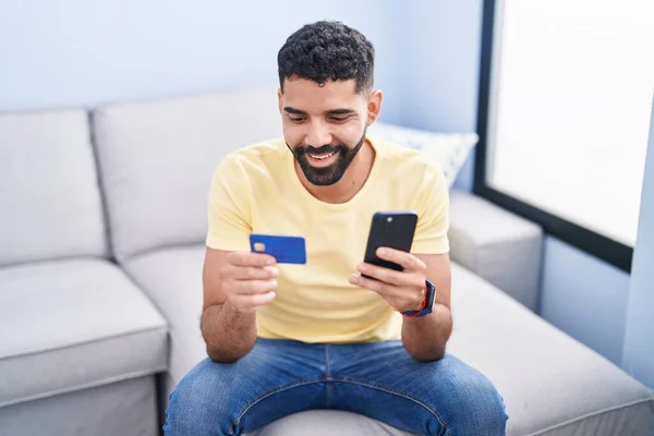 Young Arab Man Using Smartphone Credit Card Sitting Sofa Home — Foto Stock