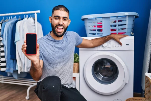 Muž Blízkého Východu Vousy Ukazující Obrazovku Smartphonu Pračku Úsměvem Hlasitým — Stock fotografie