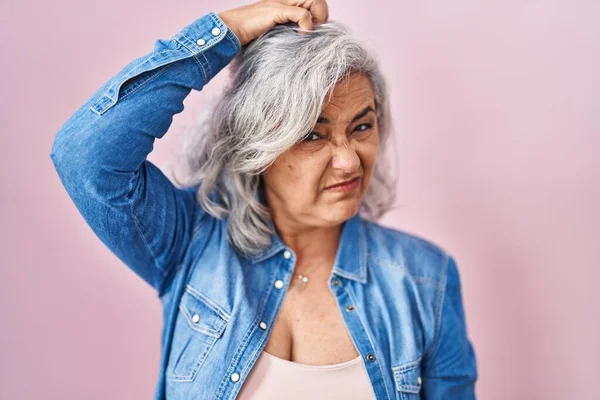 Kobieta Średnim Wieku Siwymi Włosami Stojąca Różowym Tle Myli Zastanawia — Zdjęcie stockowe