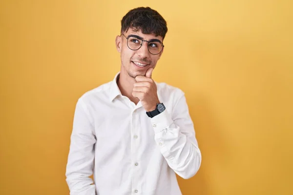Sarı Arka Planda Elleri Çenesinde Soru Sormayı Düşünen Genç Spanyol — Stok fotoğraf