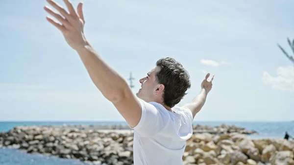 Ung Latinamerikansk Man Andas Med Armarna Öppna Stranden — Stockfoto