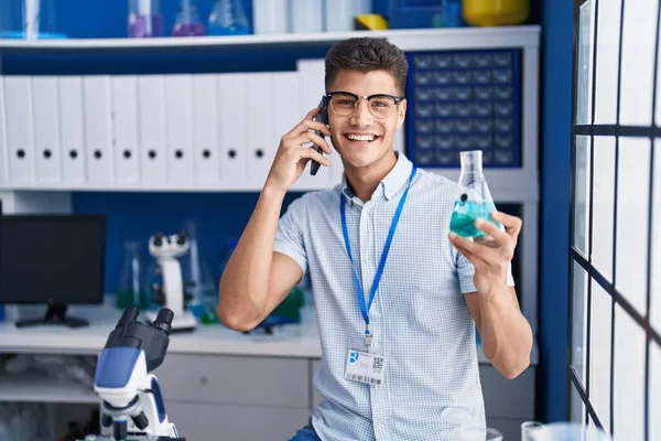 Young Hispanic Man Scientist Talking Smartphone Holding Test Tube Laboratory — Photo