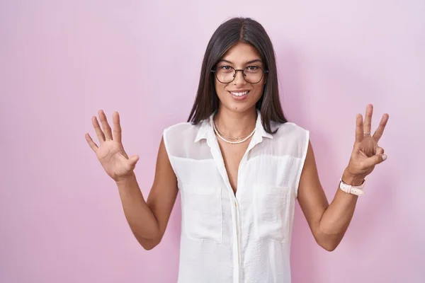 Morena Jovem Mulher Sobre Fundo Rosa Usando Óculos Mostrando Apontando — Fotografia de Stock