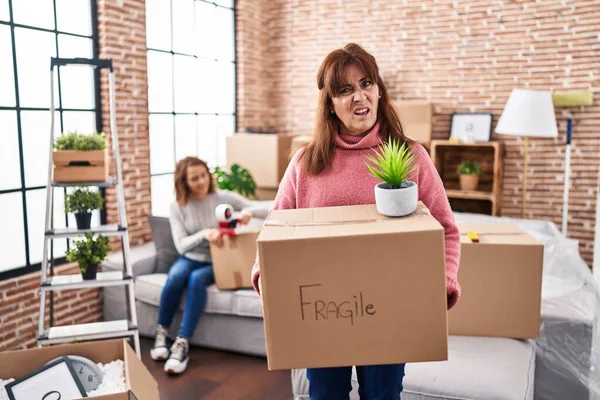 Mother Daughter Moving New Home Holding Cardboard Box Clueless Confused — Zdjęcie stockowe