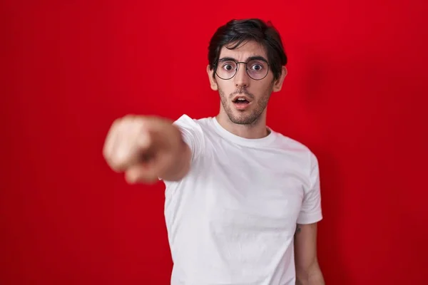 Young Hispanic Man Standing Red Background Pointing Finger Surprised Ahead — Foto Stock